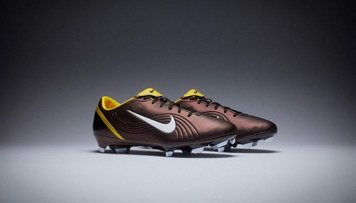 Imagem da Nike Mercurial Vapor 1 Elite FG Remake edição especial CR7, nas cores marrom, dourado e branco. A chuteira possui o cabedal FlyTouch+ que proporciona ajuste perfeito e controle de bola superior. A sola Air Zoom garante retorno de energia e a tração multidirecional com pinos chevron oferece velocidade e estabilidade. A edição limitada de 7777 pares celebra os primeiros passos de Cristiano Ronaldo no futebol, sendo um item essencial para colecionadores e jogadores.